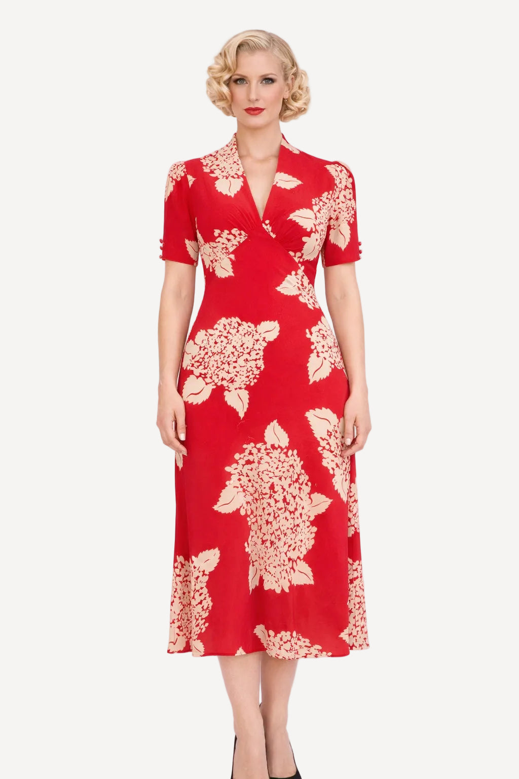 Woman wearing a red dress with white floral pattern on a white background