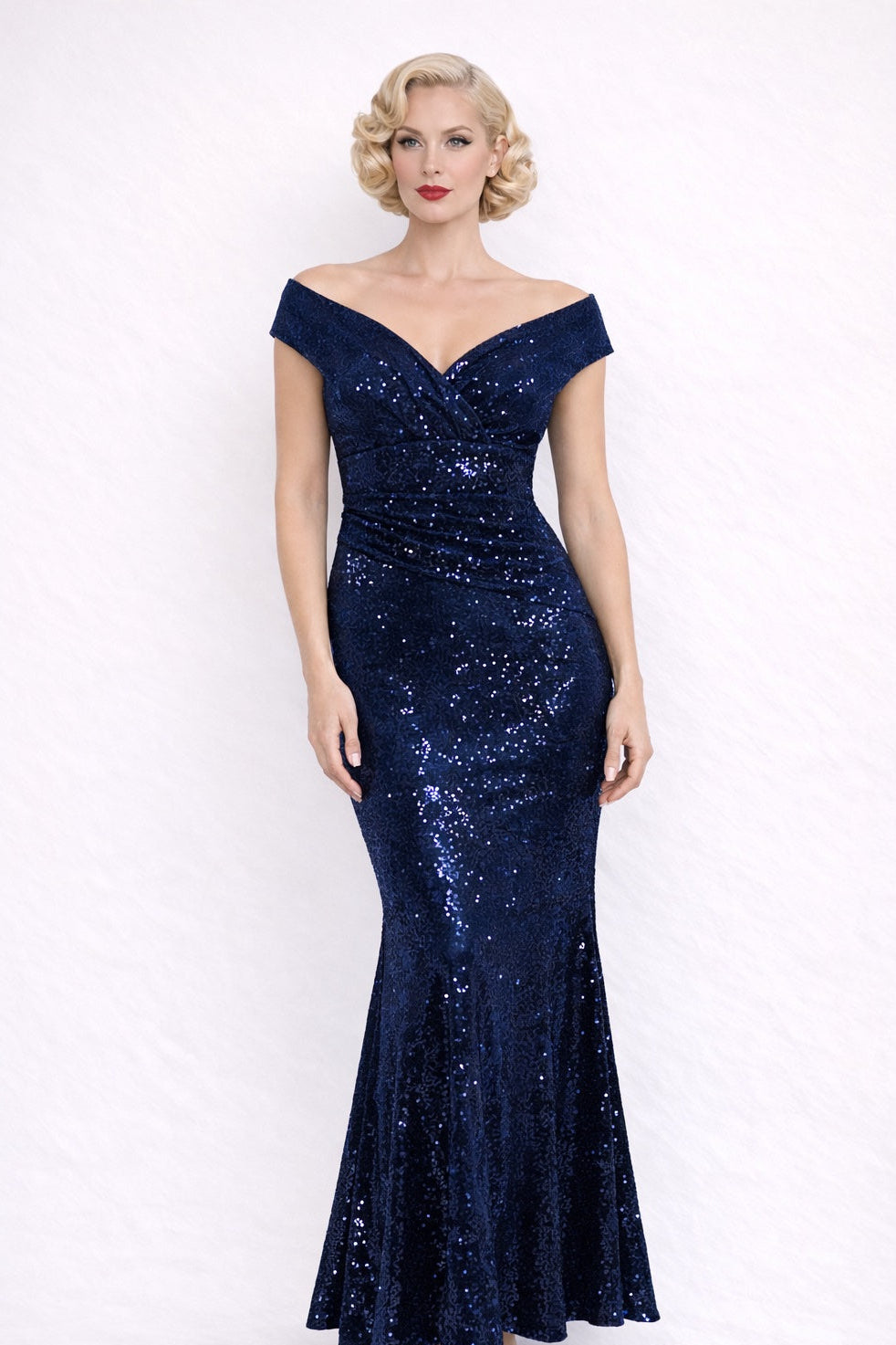 Woman wearing a blue sequin full length dress against a white background