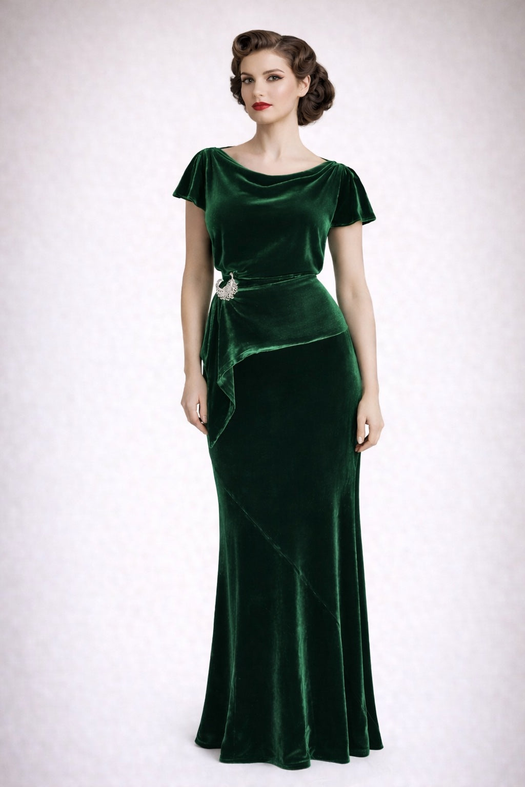 Woman wearing a full length green velvet evening dress on a white background