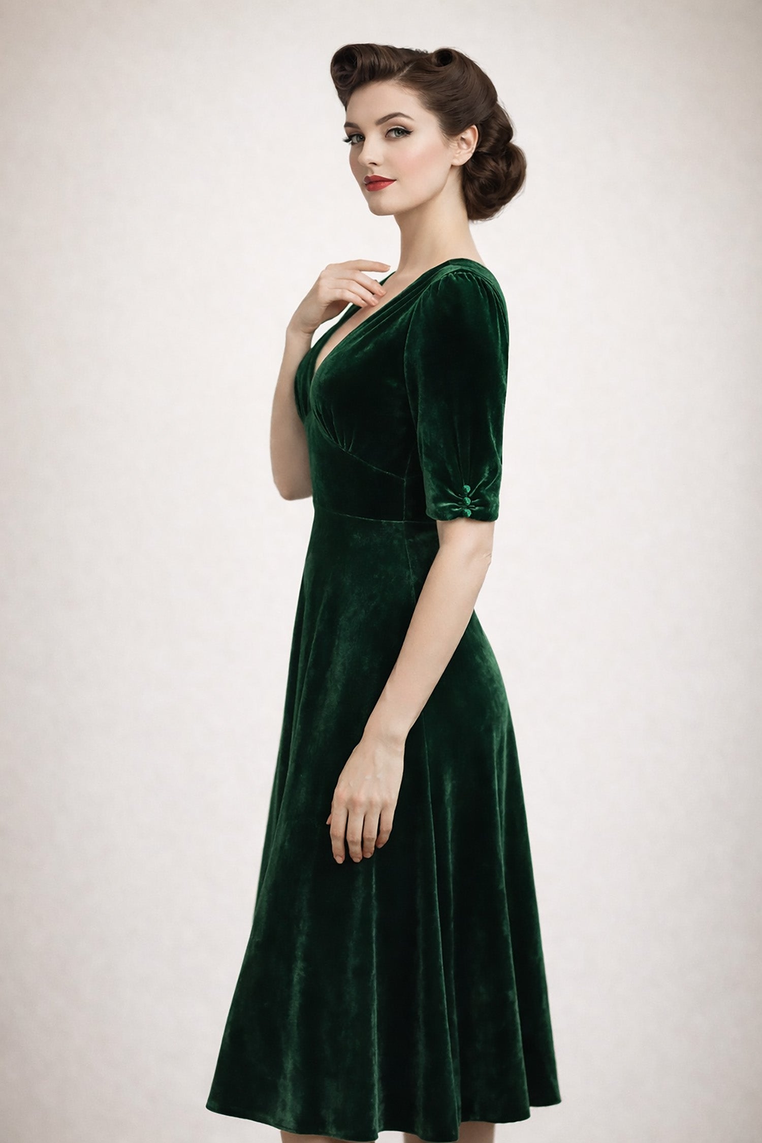Woman wearing a green velvet dress against a plain background