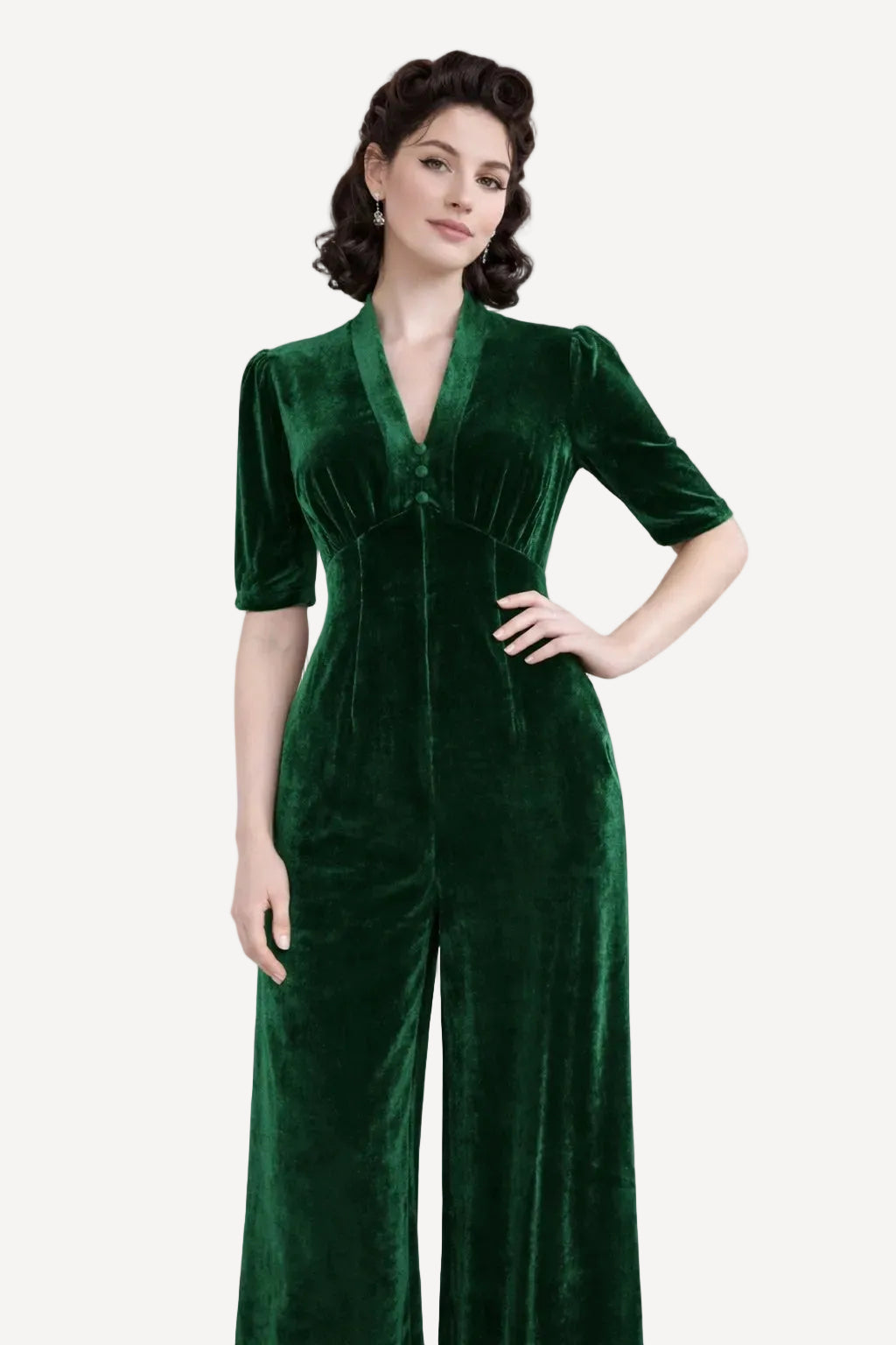 Green velvet jumpsuit worn by a model standing against a white background
