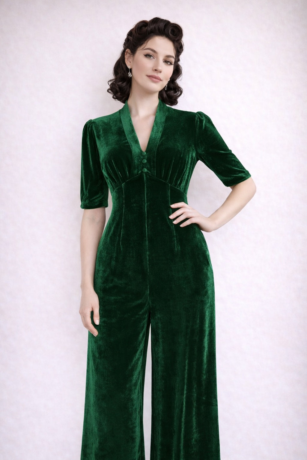 Green velvet jumpsuit worn by a model standing against a white background