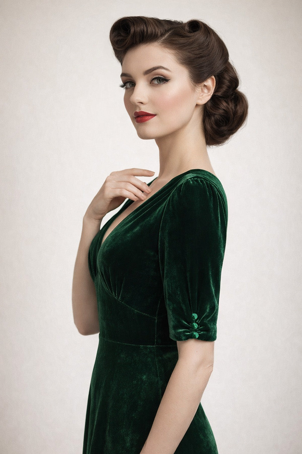 Woman wearing a green velvet dress with a plain background