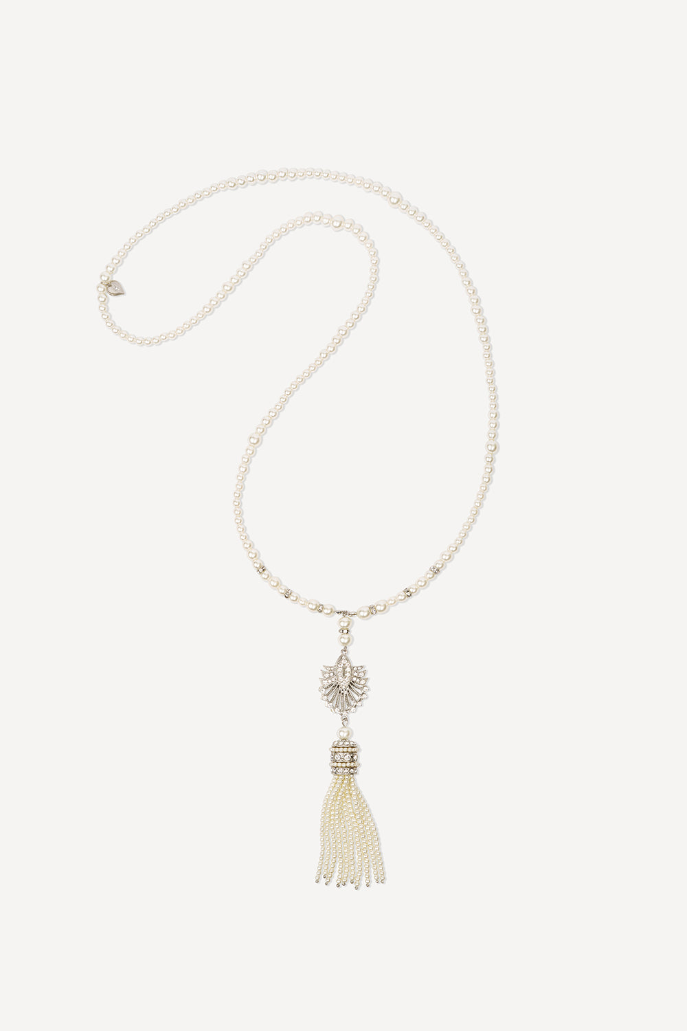 A long 1920s art deco tassel necklace with a series of small ivory pearls and a crystal fan pendant at the end, on a white background.