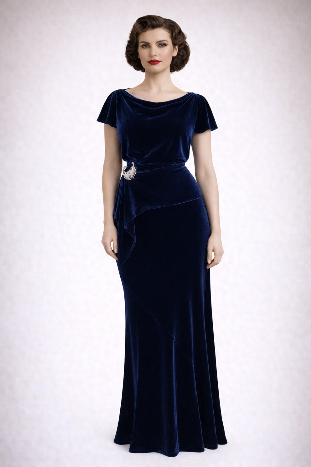 Woman wearing a navy velvet maxi dress with a belt on a white background